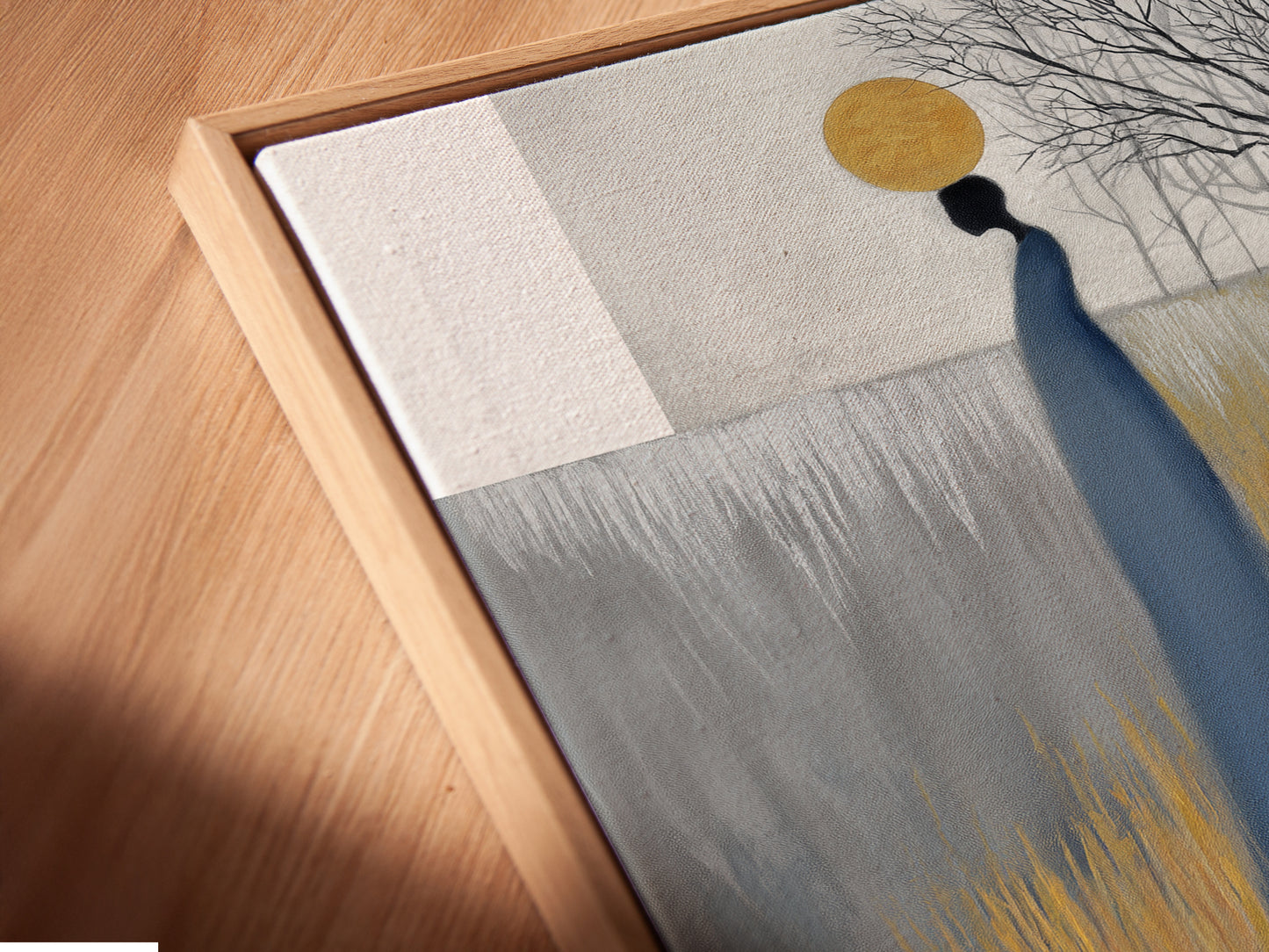A canvas print is displayed in a floating frame. The angled close-up reveals the texture and depth of the artwork. The abstract figure art combines grey blue and gold tones. This piece can elevate spaces like living rooms bedrooms and offices.