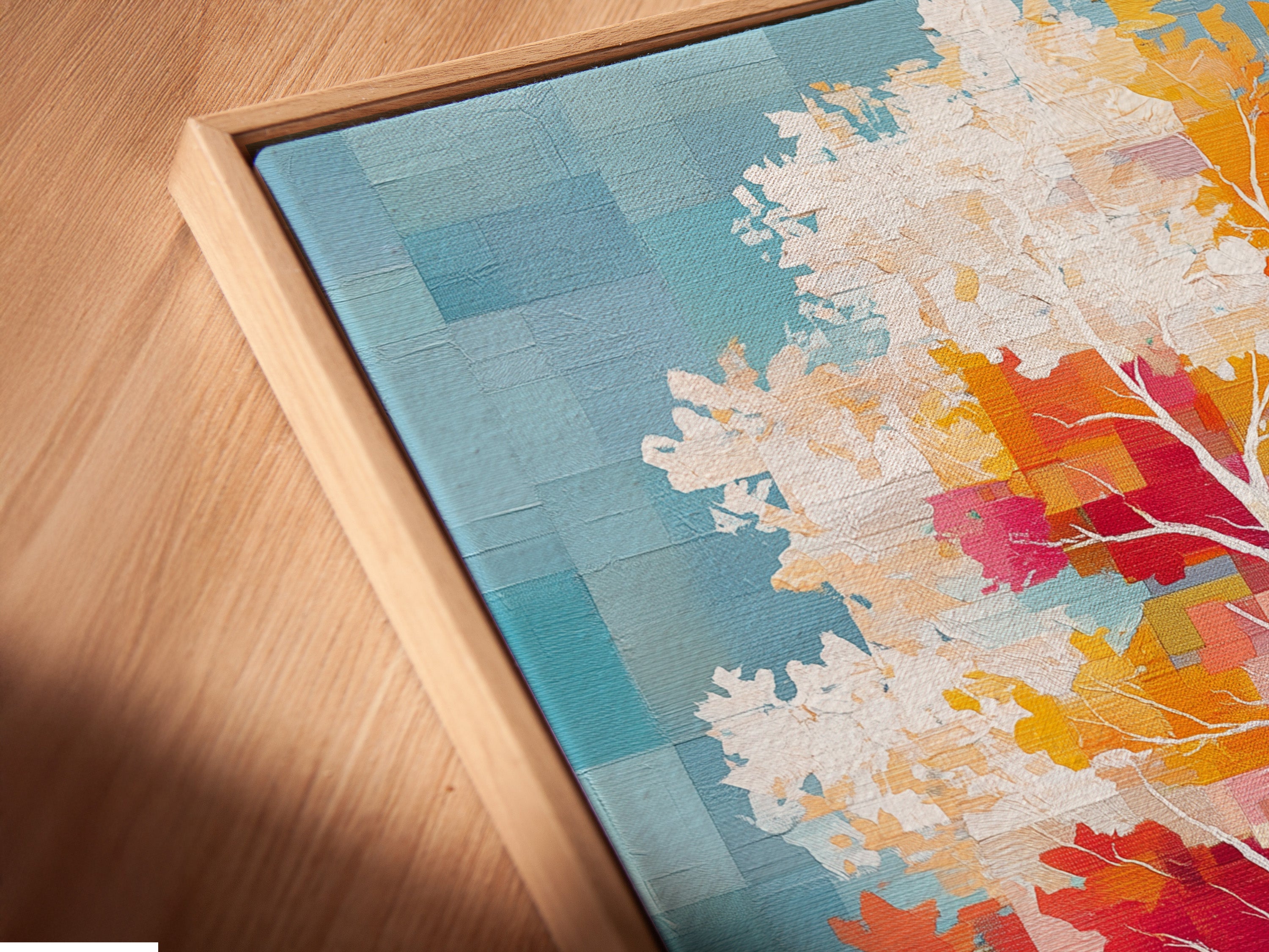 A close-up shows a canvas print in a floating frame. The colorful tree artwork stands out. This modern piece features pixelated nature elements. The autumn leaves canvas wall art is perfect for adding sophistication to your home office or living room wall decor.