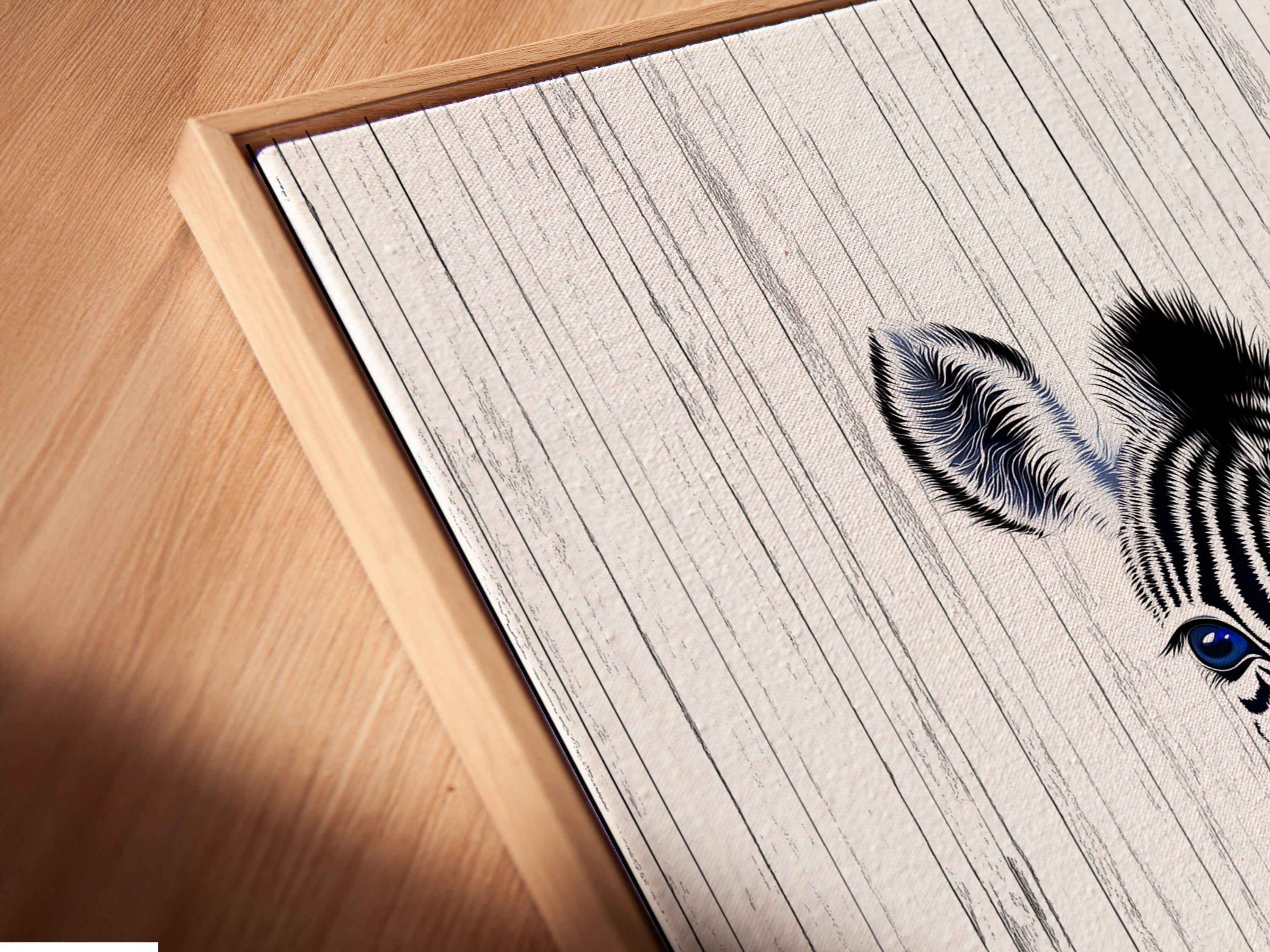 Close-up angled view of a canvas print in a floating frame. The Baby Zebra artwork is perfect for nursery wall art. This adds a modern touch to any space. The floating frame enhances the minimalist art. Black and white animal poster.