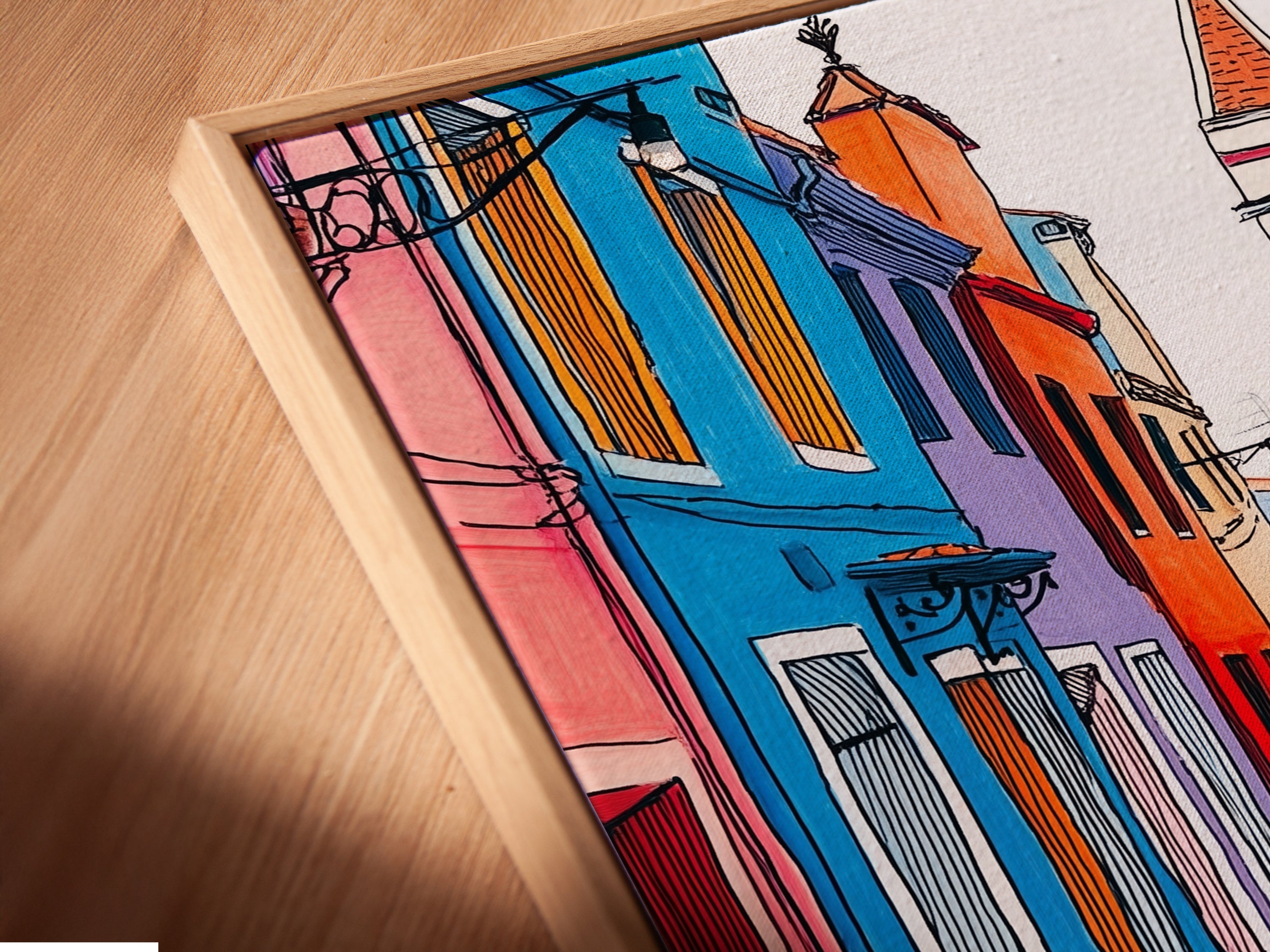A close-up angled view of a canvas print in a floating frame. Showcasing the Burano Italy artwork with colorful Italian architecture.  The floating frame enhances the modern aesthetic of this European travel poster. It is ideal for office decor.