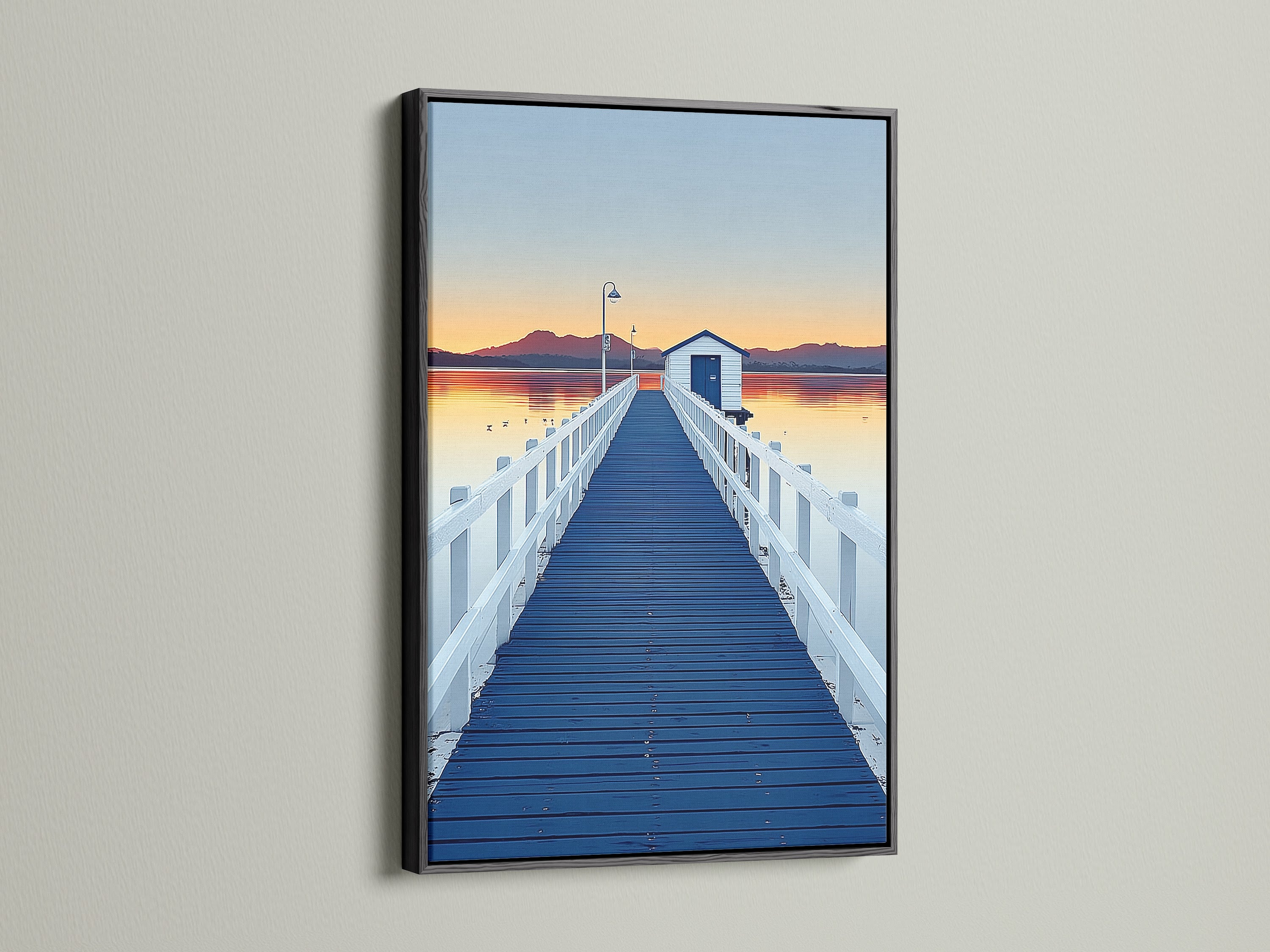 Elevate your space with dock sunset artwork.  This artwork features a blue pier wall art print in a black frame. The frame enhances the coastal scenery photography. Add a touch of modern art to your home decor.