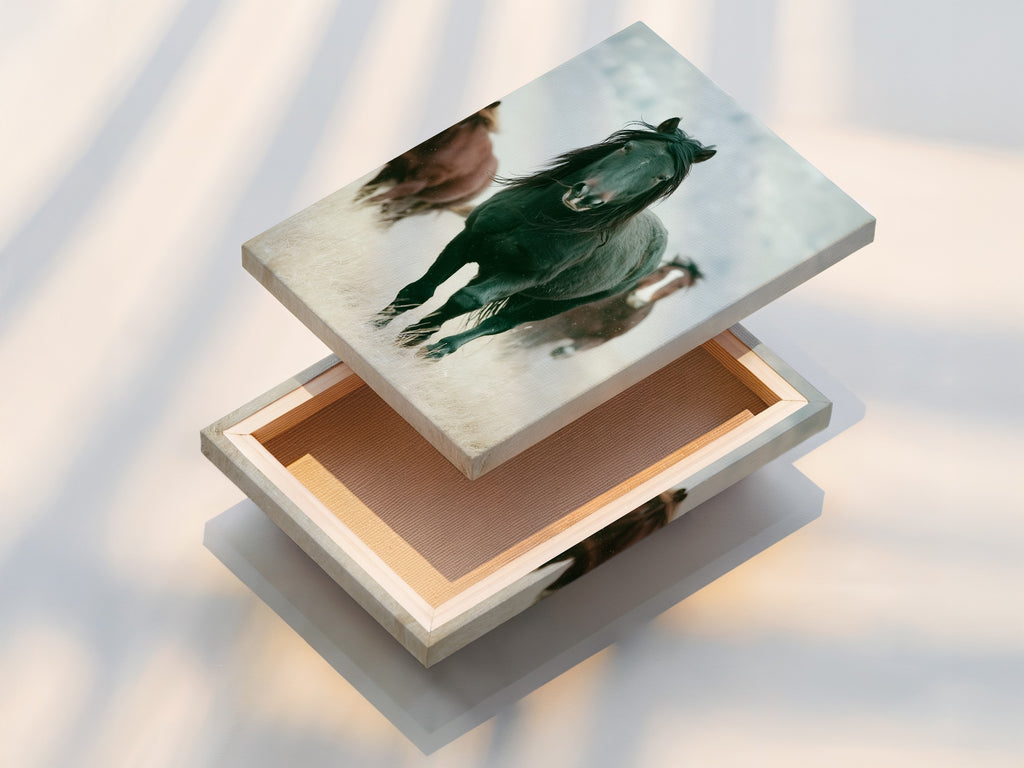 A stretched canvas print of wild horses is displayed. This Western animal wall art is ready to hang. It adds rustic charm to any space. Perfect for living rooms bedrooms or offices seeking a country or farmhouse style. This artwork is great for ranchers or anyone that appreciates wildlife art. This durable canvas brings the beauty of wildlife indoors.