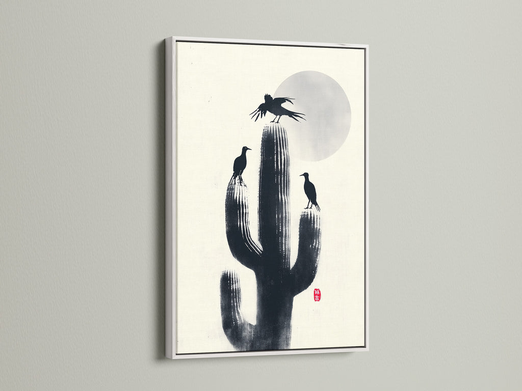 A minimalist Cactus Birds artwork print in a white frame. Black silhouettes of birds and cactus create a zen atmosphere. Ideal southwestern decor for your study room. This nature canvas adds refined style.