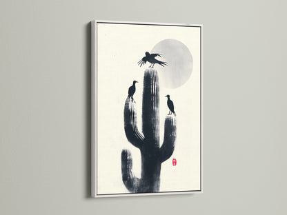 A minimalist Cactus Birds artwork print in a white frame. Black silhouettes of birds and cactus create a zen atmosphere. Ideal southwestern decor for your study room. This nature canvas adds refined style.