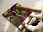 A woman carefully rolling a fine art poster paper. The fine art poster paper ensures high-quality prints. The paper is being rolled to protect it during shipping. The poster will arrive in pristine condition. High-quality paper.