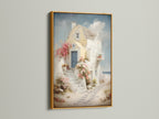 Framed coastal artwork in a gold frame. The artwork shows a Santorini-style house canvas with a blue door and floral stairway. Perfect for adding a touch of Greek island art to your vacation home decor. Ideal for bedroom wall decor.
