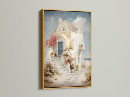 Framed coastal artwork in a gold frame. The artwork shows a Santorini-style house canvas with a blue door and floral stairway. Perfect for adding a touch of Greek island art to your vacation home decor. Ideal for bedroom wall decor.