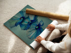 A woman carefully rolls a fine art poster paper. This ensures the safe delivery of your blue floral artwork. High-quality materials protect the modern botanical print. Get ready to enhance your space with beautiful wall decor. Order now for pristine art