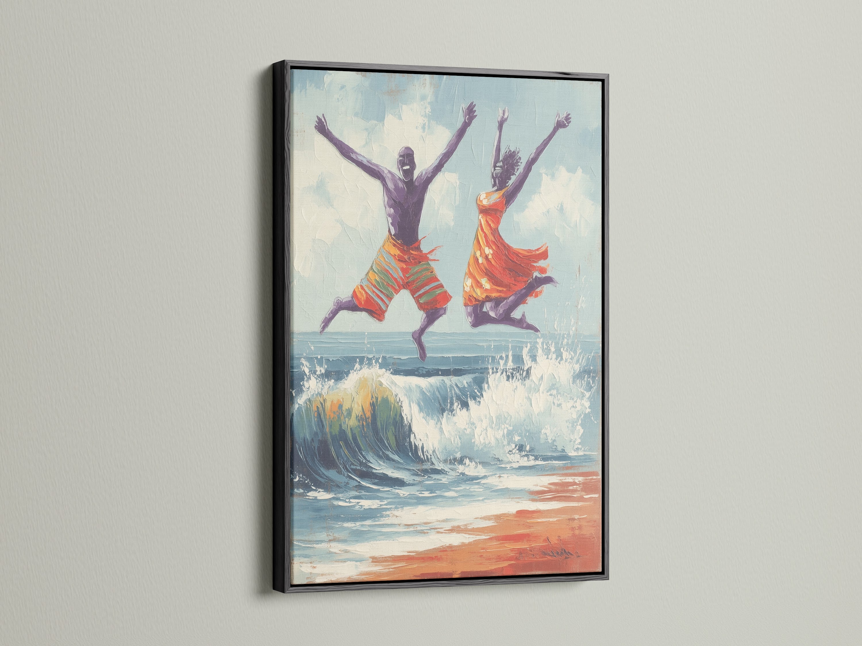 Joyful seascape wall art in a black frame. The artwork portrays a man and women jumping over a wave on the beach. The black frame offers a bold modern look. Add this coastal artwork to your living room