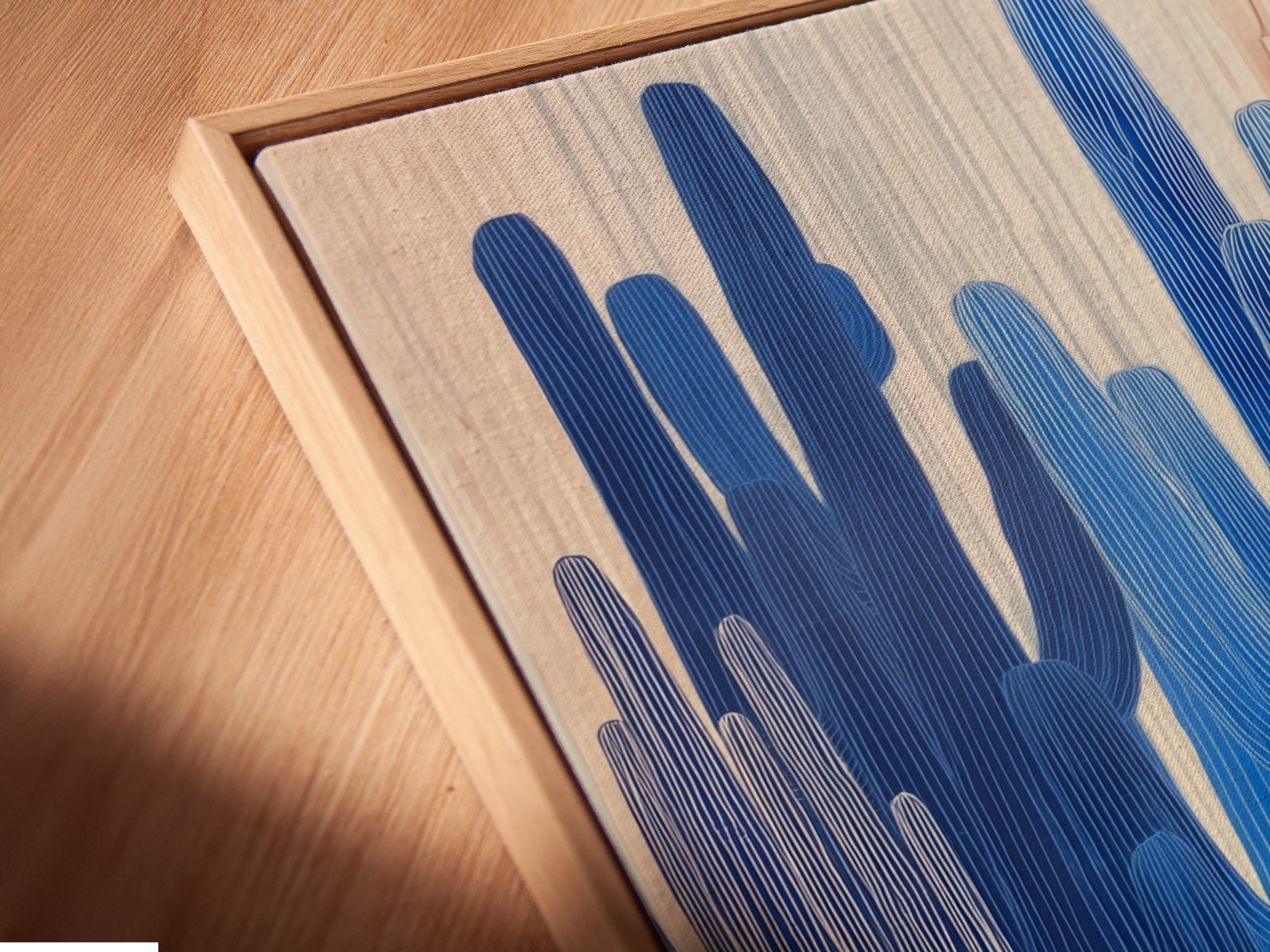 Angled close up of a canvas print in a floating frame. A modern way to display blue botanical artwork. Perfect for showcasing desert canvas prints. Enhance your home office decor with floating frames.