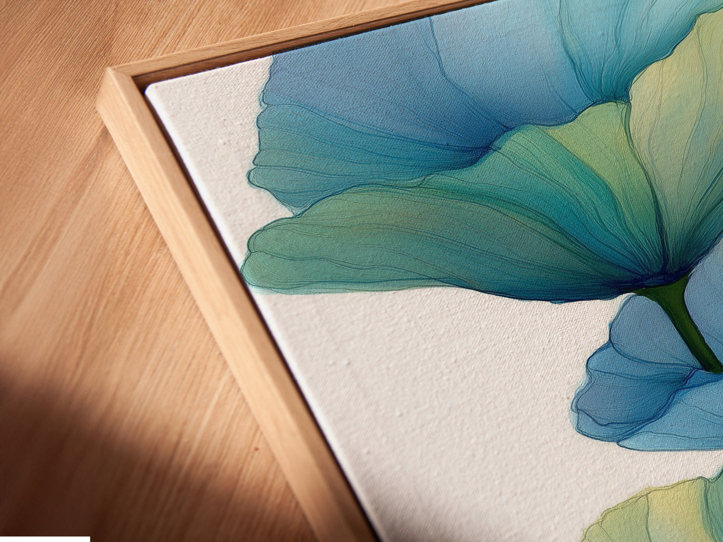 This is a close-up of a canvas print in a floating frame. The artwork features a blue floral. The floating frame gives the teal flower poster a modern look. Perfect for adding a sophisticated touch to any room.