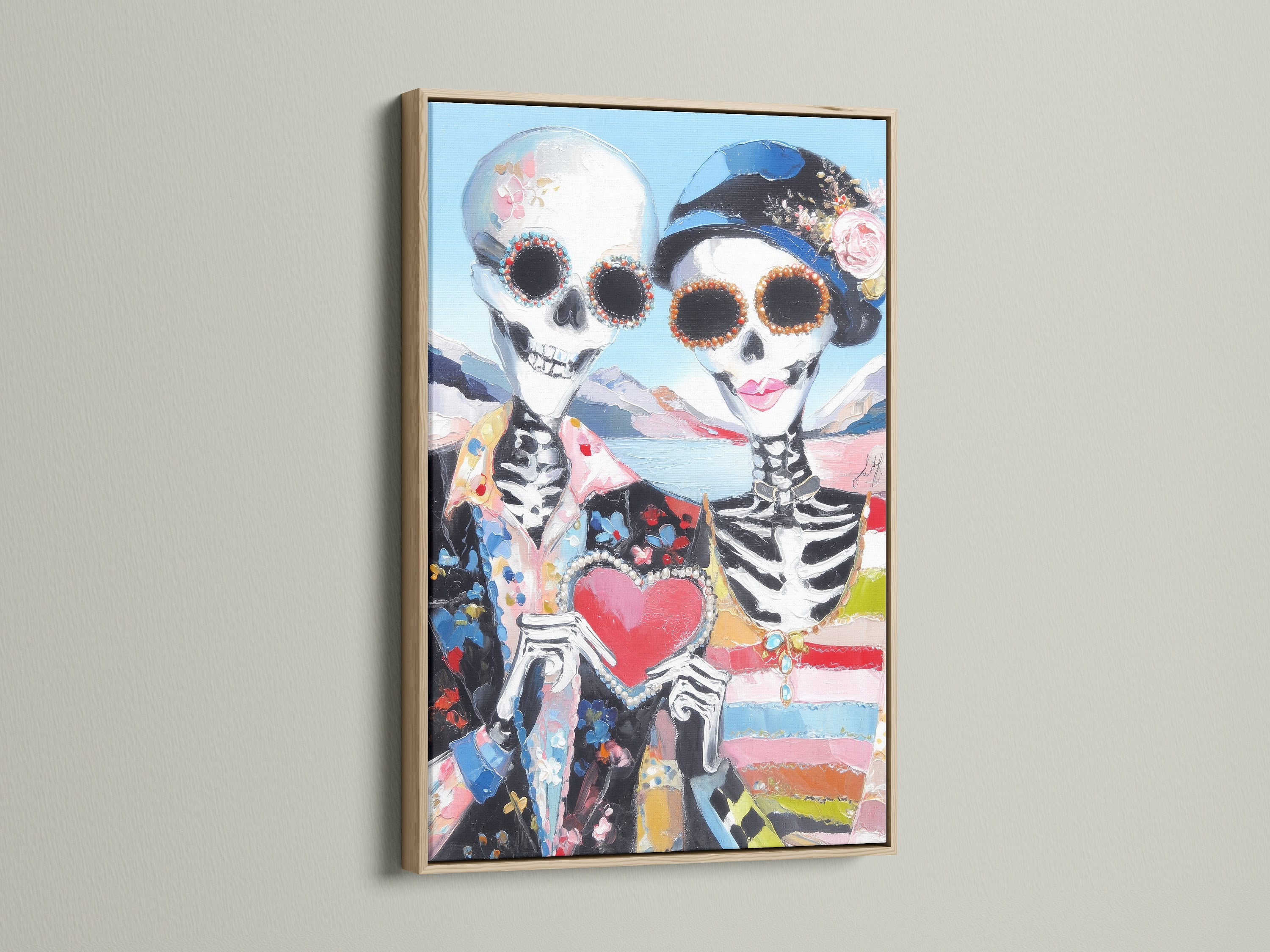 Dia de los Muertos art in an oak frame. The calavera print shows a sugar skull couple holding a heart. This gothic decor piece adds a touch of Mexican art to any space. Perfect for ofrenda decor.