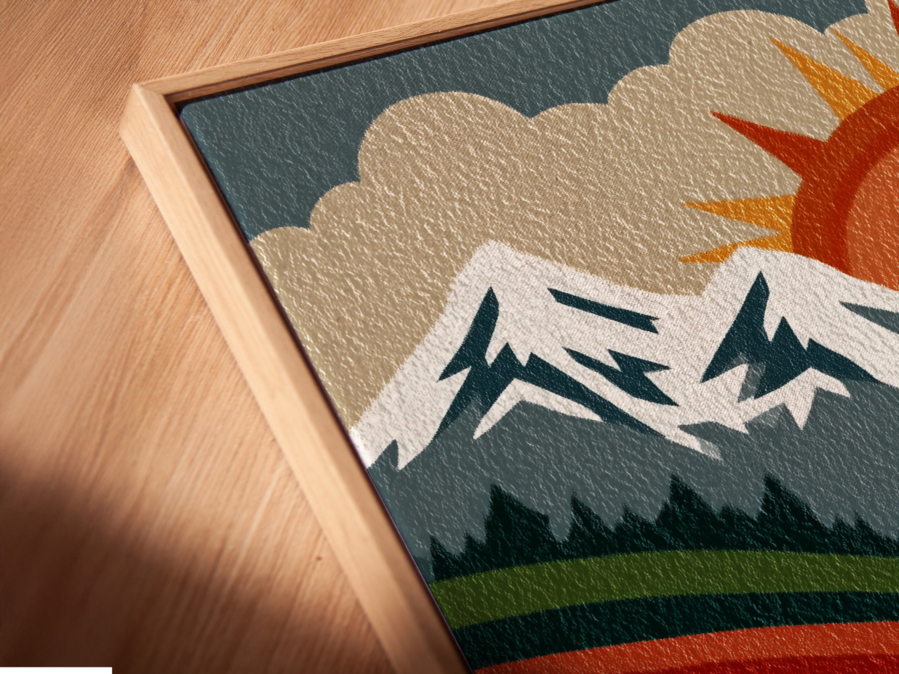 Close up angled shot of a canvas print in a floating frame. The mountain landscape artwork features a retro sun mountains and valley. The floating frame gives a modern gallery like appearance. This enhances the artwork's visual appeal.