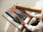 A woman is carefully rolling a fine art poster paper. The paper features a desert cactus artwork. This high-quality print captures the essence of the southwest. Perfect for framing or displaying as is. Add a touch of western charm to your home decor.