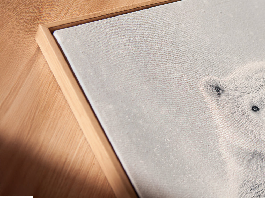 A close-up angled view reveals a canvas print of a polar bear in a floating frame. The floating frame enhances the minimalist animal photography creating a gallery-like display. This bear canvas print is ideal for modern wall decor.