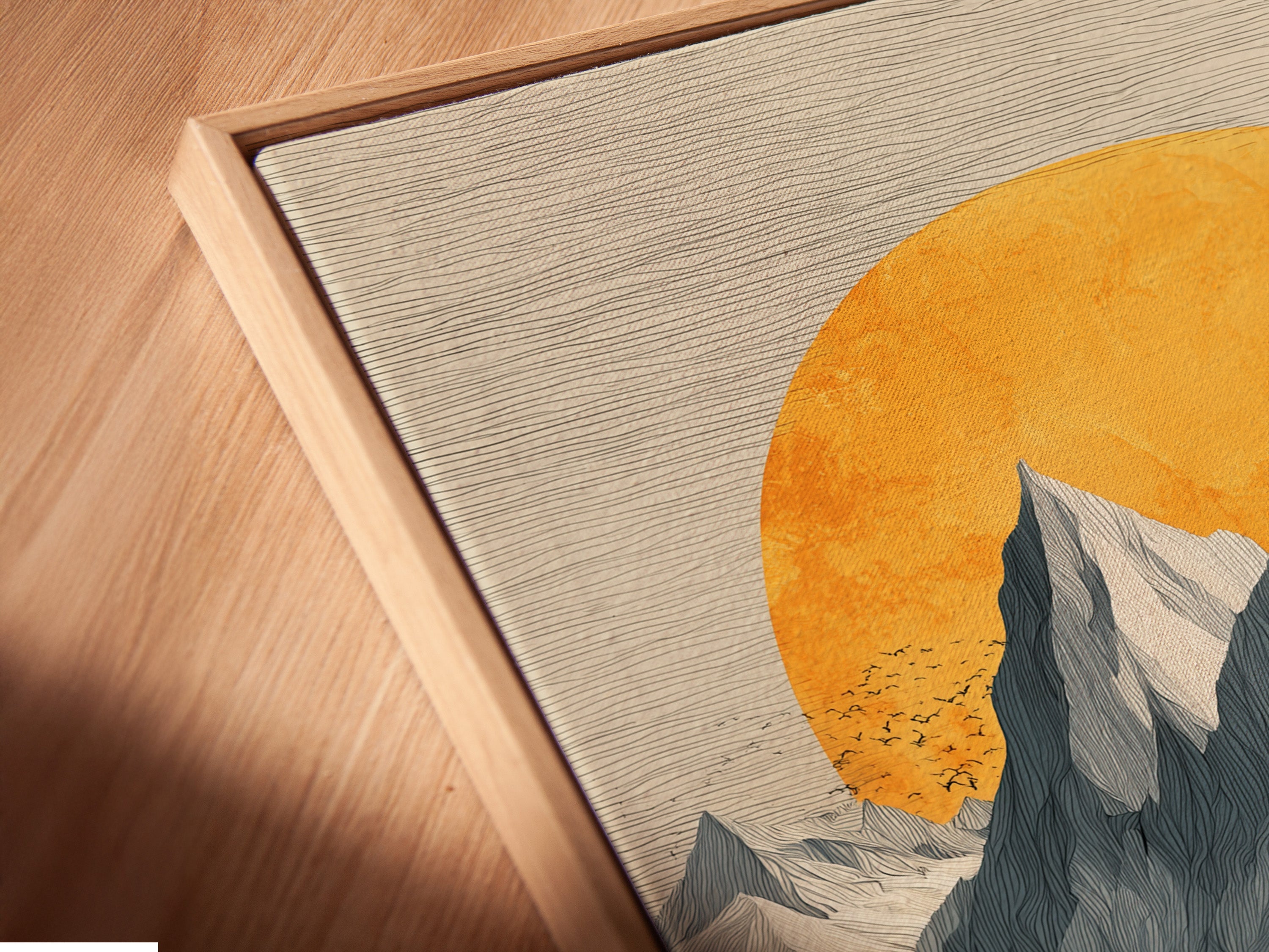 A close-up angled view of a canvas print in a floating frame. The Mountain Sunset artwork is vintage alpine wall art. Orange and gray tones create a calming nature print. This piece enhances any room's decor. Perfect for those seeking modern wall art.