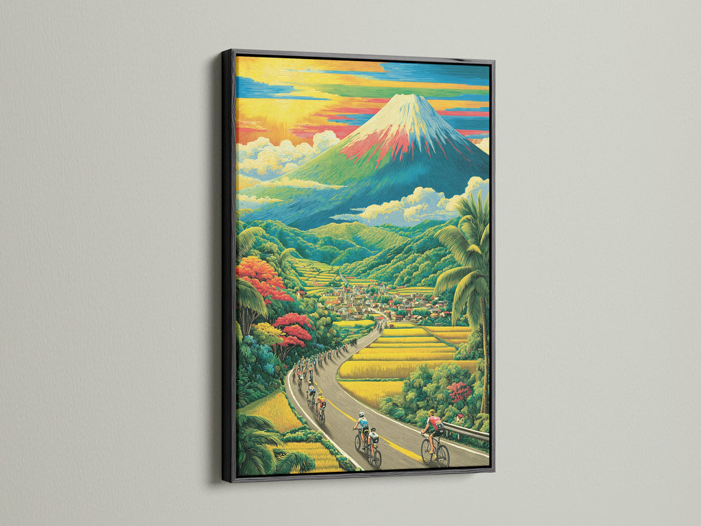 Landscape artwork framed in a sleek black frame is on display. The scene includes cyclists riding along a winding road. There is a charming village and a majestic mountain. The black frame adds a touch of sophistication.