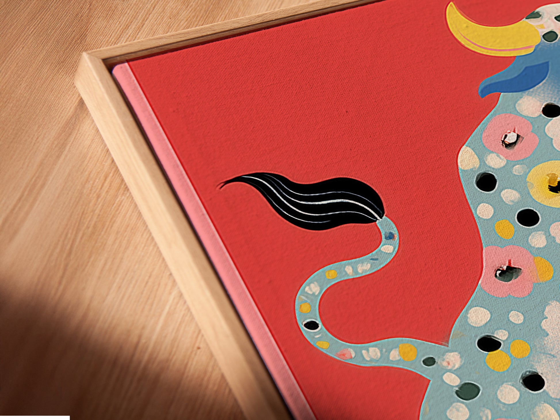 Angled close up of a Floral Bull canvas print in a floating frame. The floating frame enhances the artwork's modern appeal. The colorful bull with floral accents is a focal point. This animal artwork brings a touch of folk art charm. Perfect for adding character to any space.