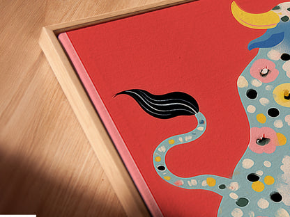 Angled close up of a Floral Bull canvas print in a floating frame. The floating frame enhances the artwork's modern appeal. The colorful bull with floral accents is a focal point. This animal artwork brings a touch of folk art charm. Perfect for adding character to any space.