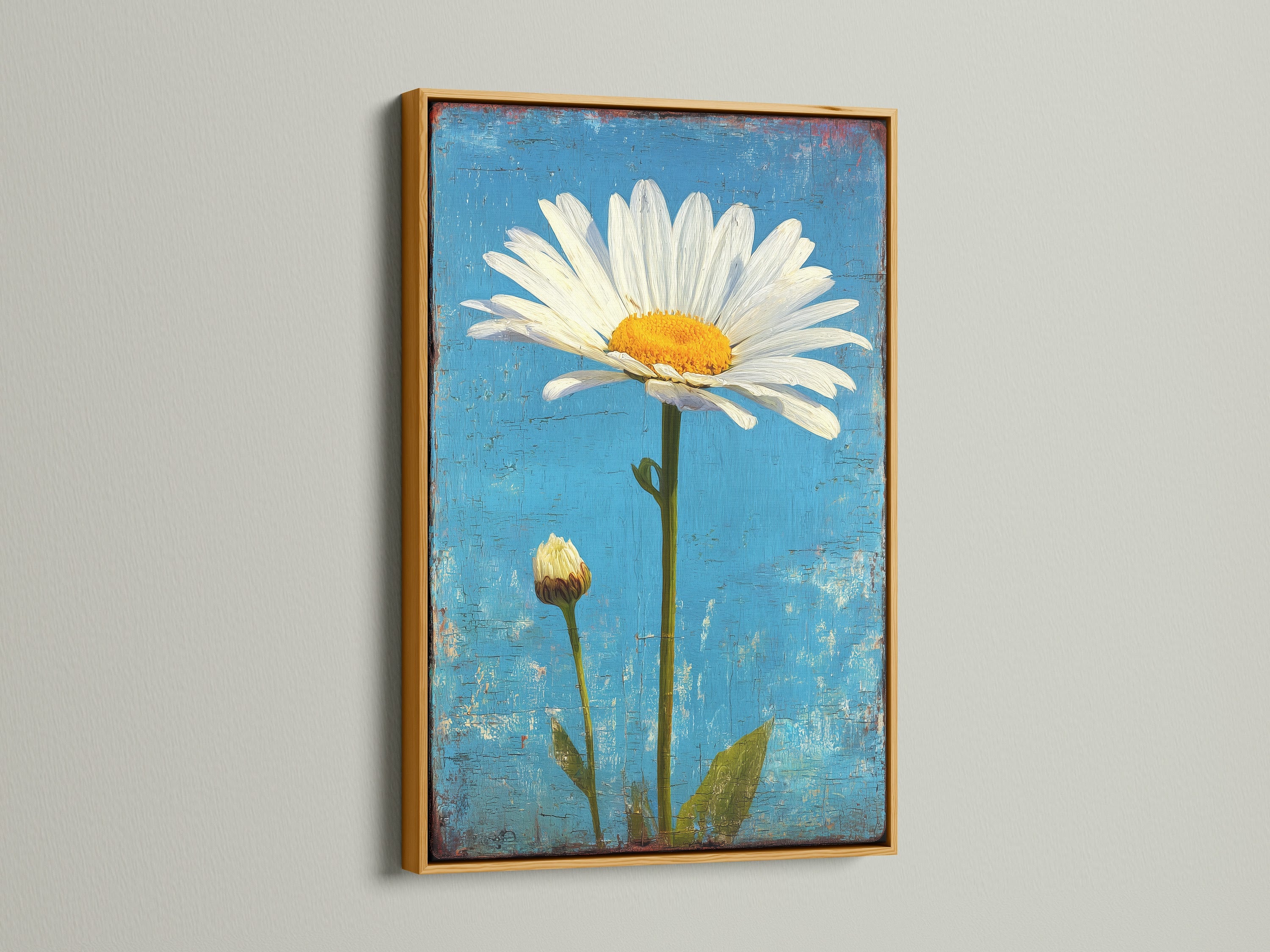 A gold frame surrounds artwork of a white daisy with a bud on a blue background. The gold frame adds a touch of elegance to this floral art. This piece enhances your interior with a sophisticated botanical theme.
