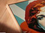 Angled close up of a canvas print in a floating frame. Retro Woman Art in vintage pop art style wall decor. The artwork features red hair and teal orange hues. The contemporary art is great for any room.
