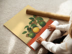 A woman carefully rolling a fine art poster paper of the Citrus Fruit Artwork. The fine art poster paper ensures a high-quality print. Perfect for modern kitchen wall decor and botanical prints. Ideal for still life artwork.