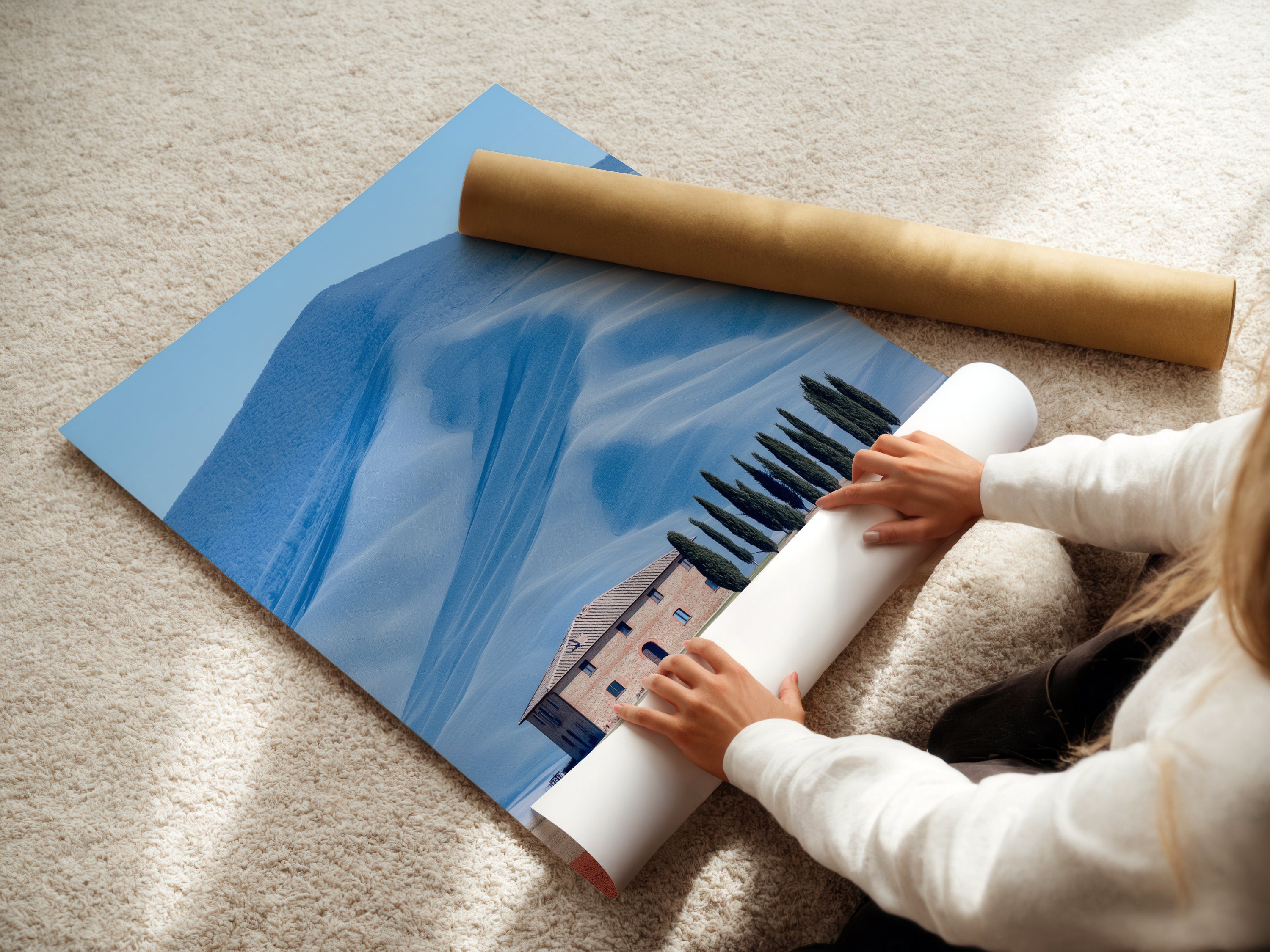 A woman is carefully rolling a fine art poster paper featuring a Tuscany landscape. This Italian countryside art is perfect for home decoration. It is ideal for adding farmhouse scenery to your walls. This landscape is great for rustic and Tuscan style interiors.