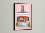 Artwork presented in a black frame. The art captures a bakery storefront with pink walls and a blue awning. The black frame offers a bold and sophisticated contrast. This piece is perfect for adding a stylish statement to your home decor with its striking presence.