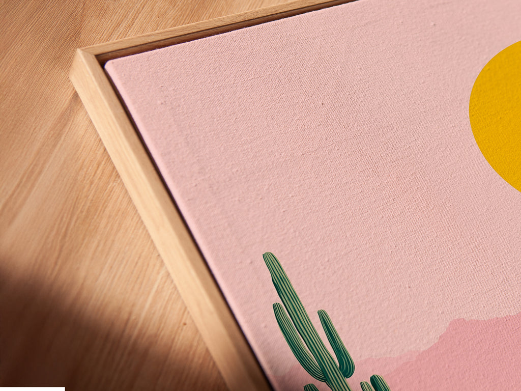 A close-up shot reveals a Desert Oasis canvas print in a floating frame. The artwork appears to float adding a modern touch. The pink and teal colors are vivid. This offers a unique and stylish way to display your art.