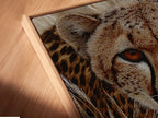 A close-up of a cheetah canvas print in a floating frame. The frame gives the artwork depth and dimension. The artwork seems to float against the wall. The floating frame enhances the contemporary feel of the safari artwork.