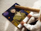 A woman is carefully rolling a fine art poster paper featuring the Cosmic Woman Portrait. This surreal galaxy artwork can be displayed in multiple ways. The celestial wall art is ideal for modern bedroom decor. The dreamy space art is perfect for art galleries.