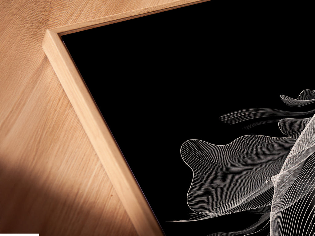 An angled close up reveals a canvas print of a black and white whale in a floating frame. The minimalist ocean canvas print appears to float adding depth. Ideal for a contemporary aesthetic. The floating frame enhances the whale artwork. This is a unique piece for any space.