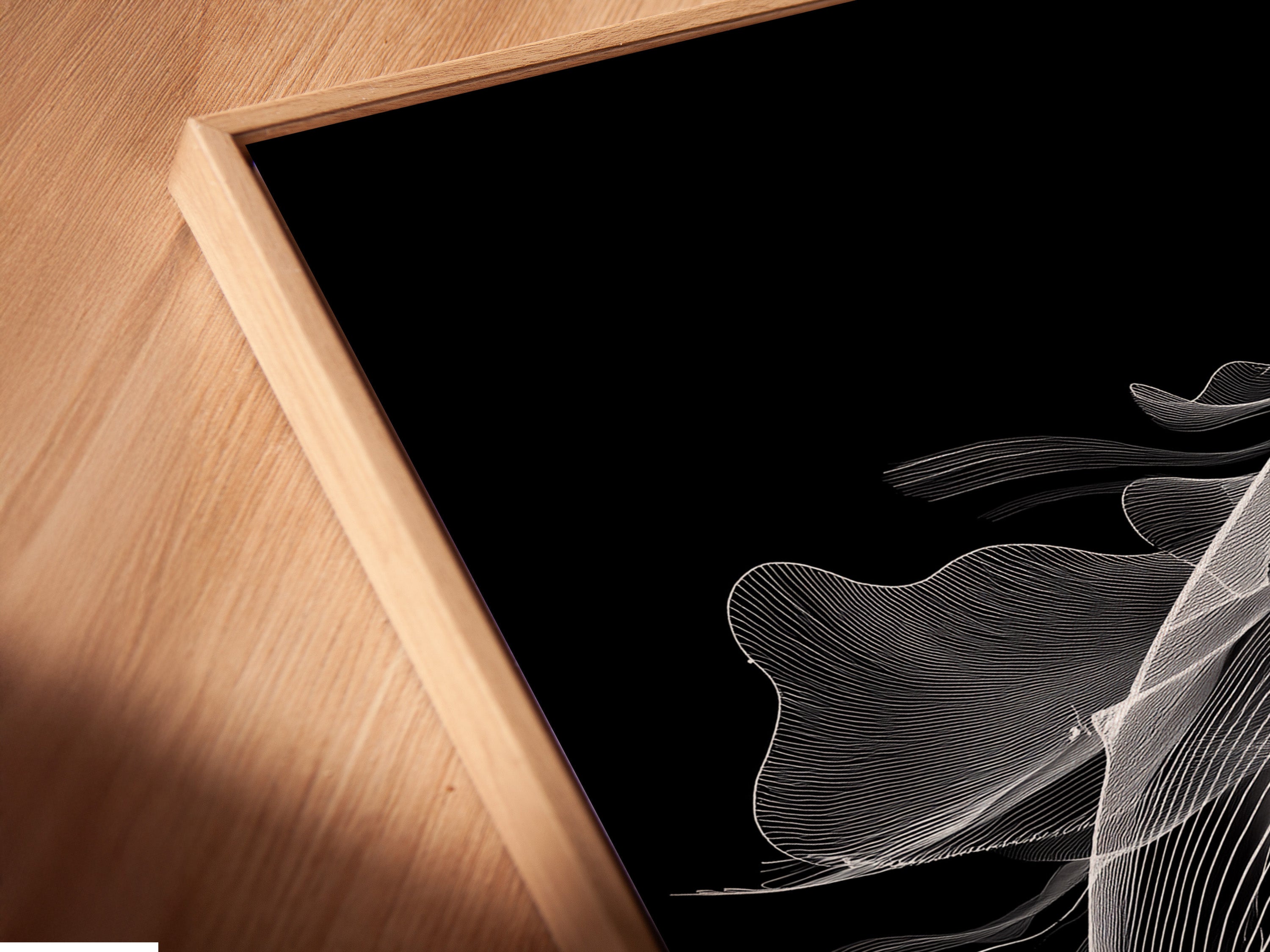 An angled close up reveals a canvas print of a black and white whale in a floating frame. The minimalist ocean canvas print appears to float adding depth. Ideal for a contemporary aesthetic. The floating frame enhances the whale artwork. This is a unique piece for any space.