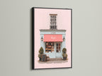 An eye-catching art print is displayed in a sleek black frame. The artwork shows a picturesque building with a pink facade and a bold red awning. The black frame adds a touch of drama and sophistication. It makes the artwork pop. This piece is perfect for creating a focal point in your home.
