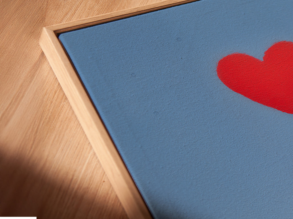 A close-up angled view of a canvas print in a floating frame. The artwork depicts a medical team with a red heart balloon. The floating frame gives a modern gallery look. Perfect for healthcare art or hospital wall decor. The artwork celebrates medical heroes.