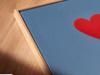 A close-up angled view of a canvas print in a floating frame. The artwork depicts a medical team with a red heart balloon. The floating frame gives a modern gallery look. Perfect for healthcare art or hospital wall decor. The artwork celebrates medical heroes.