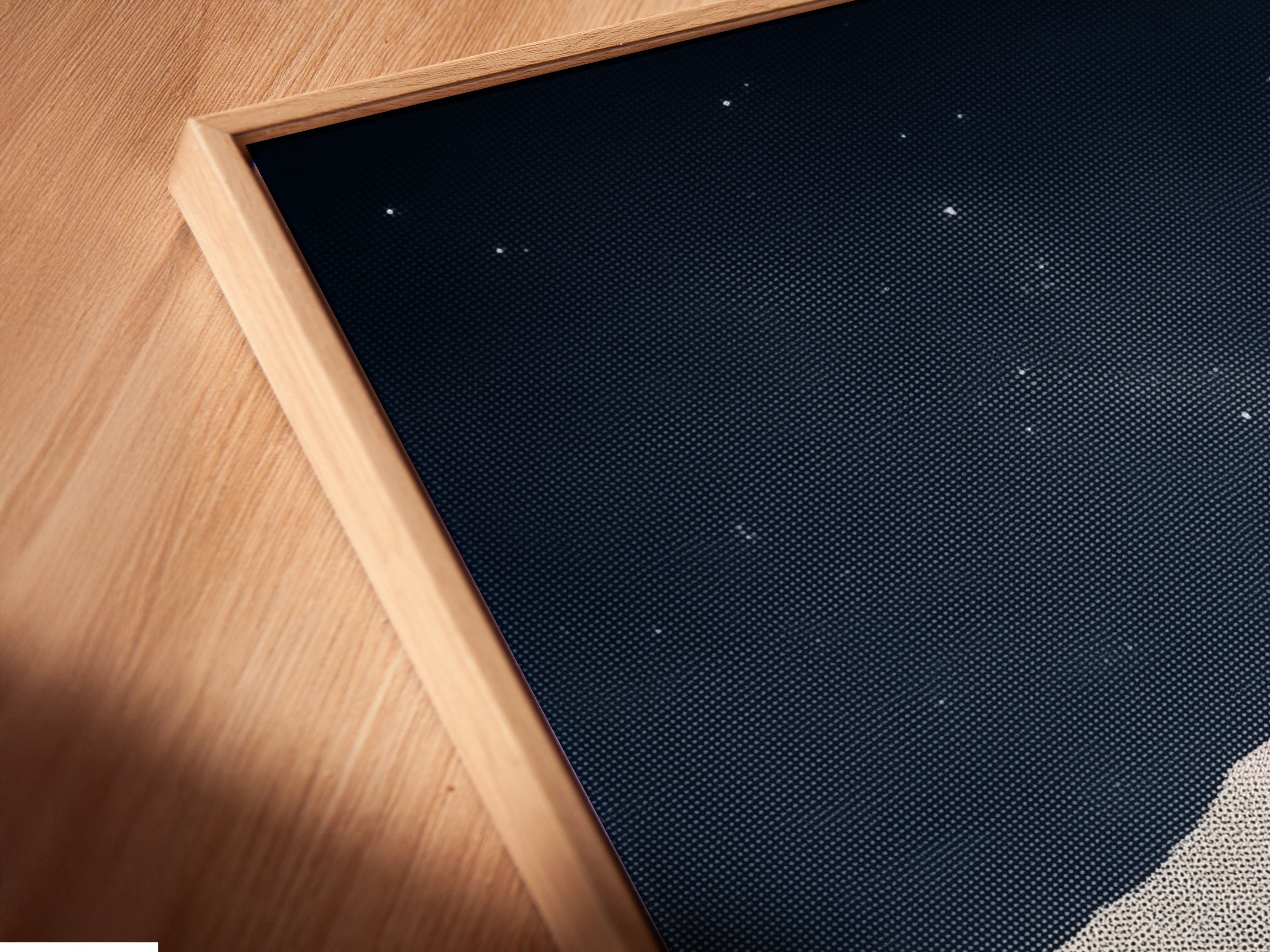 This is a close-up angled view of a canvas print in a floating frame. The Mountain Galaxy artwork is beautifully displayed. The frame enhances the artwork's modern aesthetic. It's perfect for adding sophistication to any room. The art combines celestial and landscape elements.