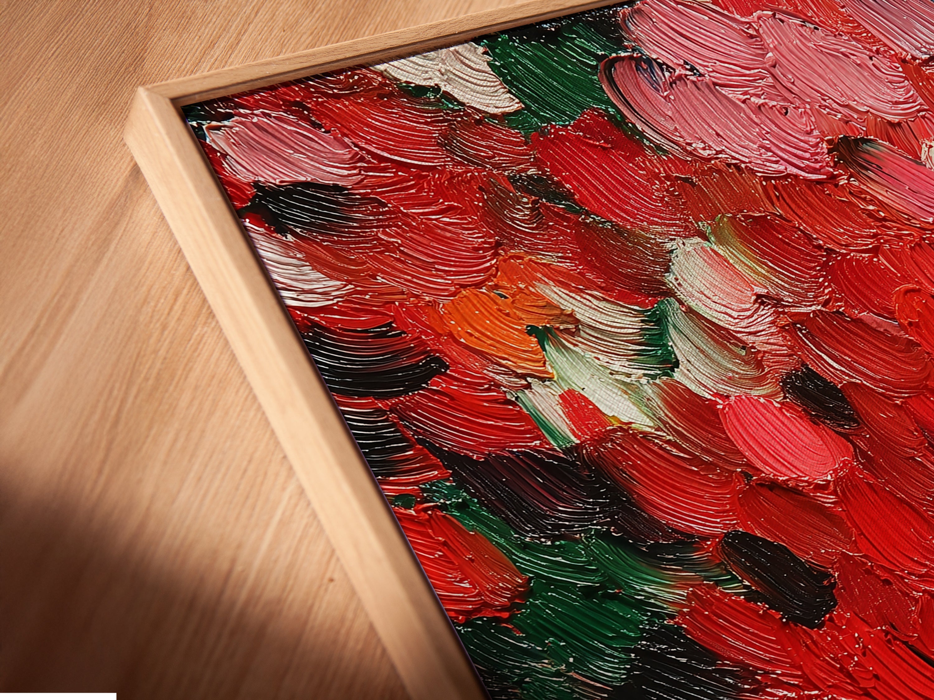 A close-up angled view of a canvas print in a floating frame is showcased. The abstract red artwork features a textured impasto technique. This contemporary palette knife art is perfect for bedroom decor. It adds a modern and sophisticated touch to any interior space. It is ideal for colorful wall decor.