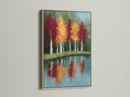 Framed autumn trees artwork with an oak frame. The reflected landscape wall art showcases a teal blue lake painting. It is ideal for creating a cozy rustic atmosphere in your living room or bedroom. The oak frame enhances the natural beauty.