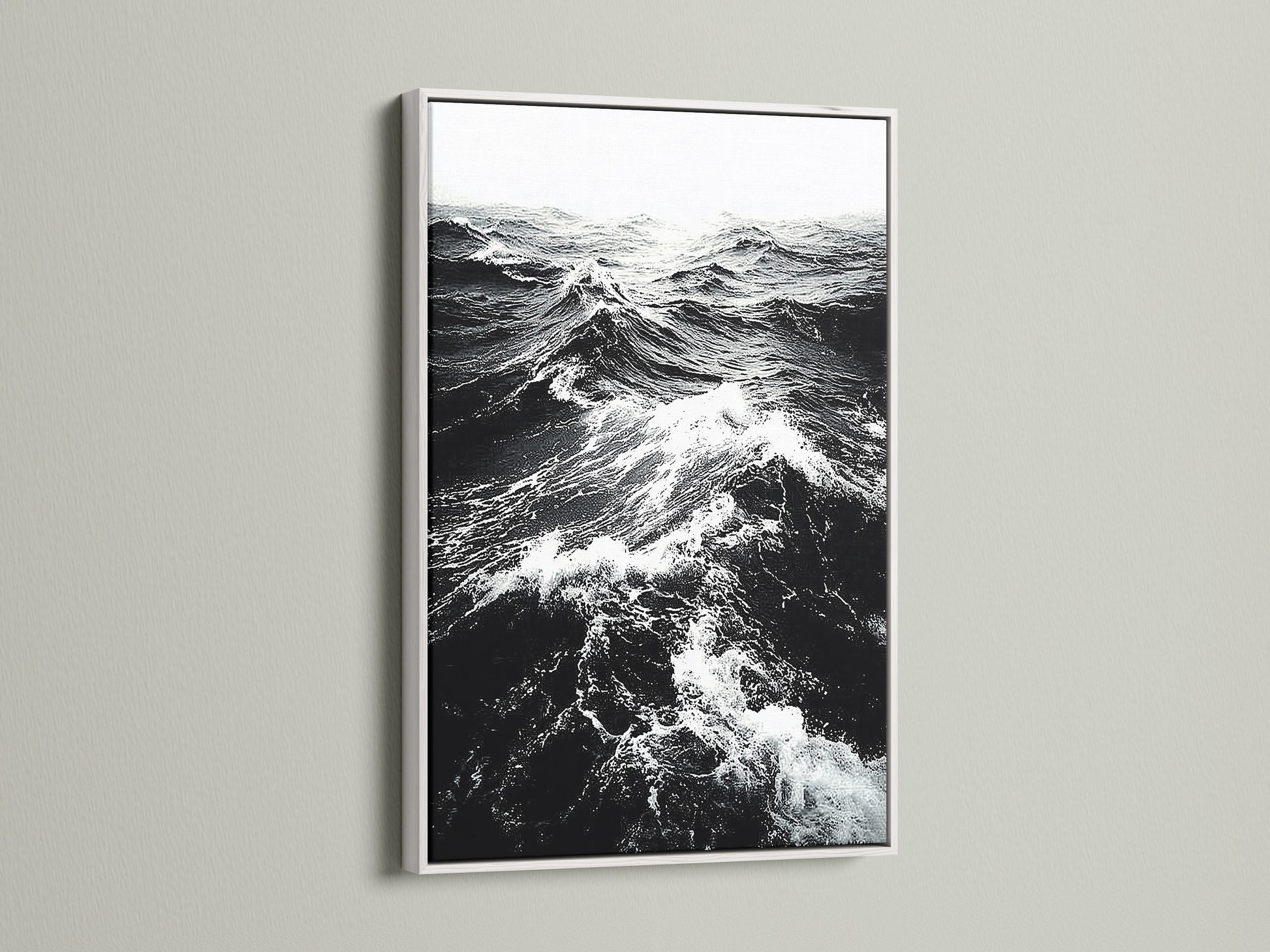 A white frame showcases black and white ocean wave artwork. The crisp white frame enhances the sea print. It provides a clean modern look for any room. Shop our coastal wall art collection today.