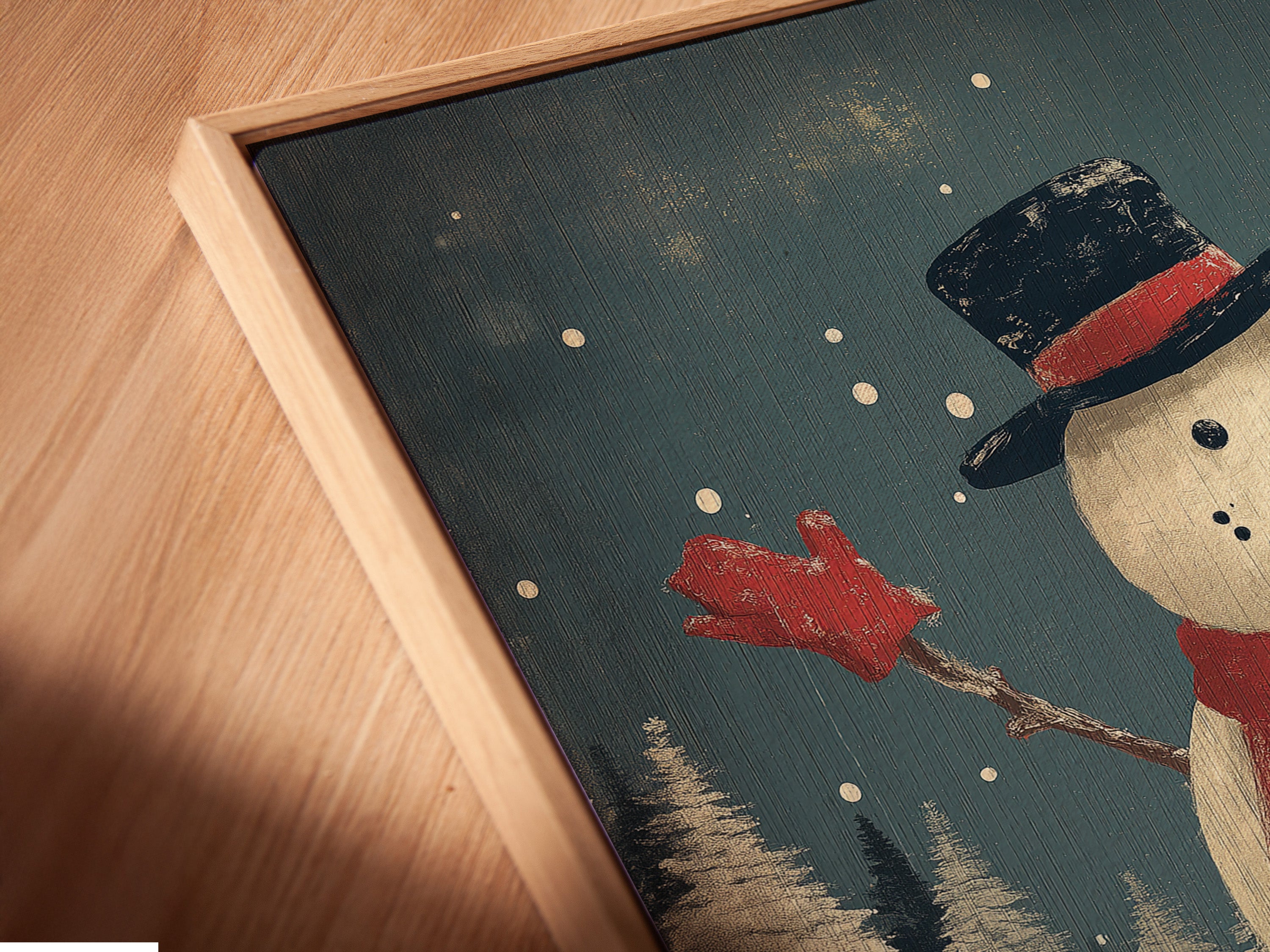 A close-up angled view reveals the texture of a canvas print in a floating frame. This snowman winter art print adds depth and dimension to the artwork. It is perfect for christmas wall decor.