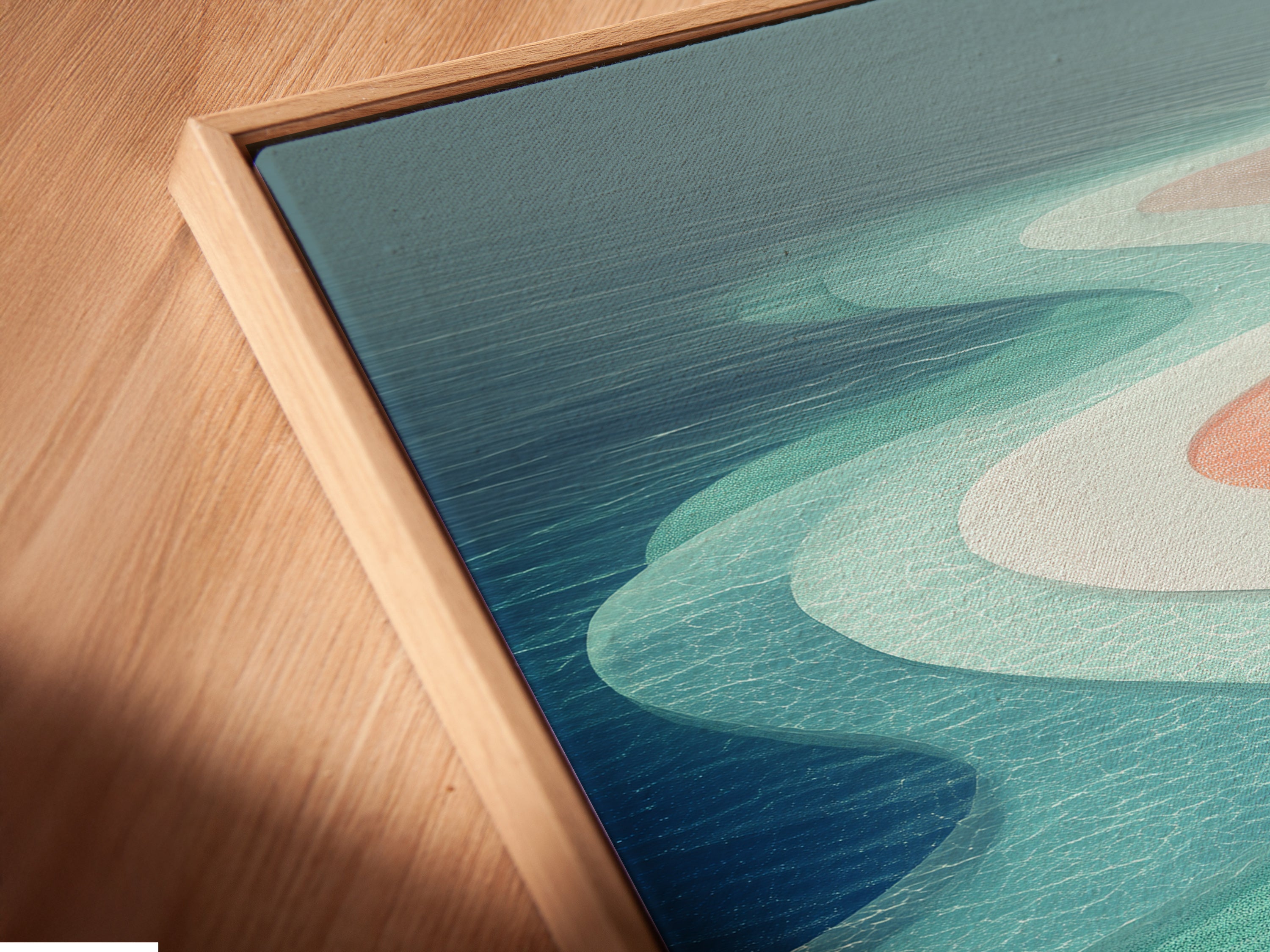 A close up shows a canvas print in a floating frame. The abstract beach artwork features teal and pink hues. This modern coastal art brings the ocean to your space. Its unique frame adds depth and style. Perfect for enhancing your bedroom wall decor.