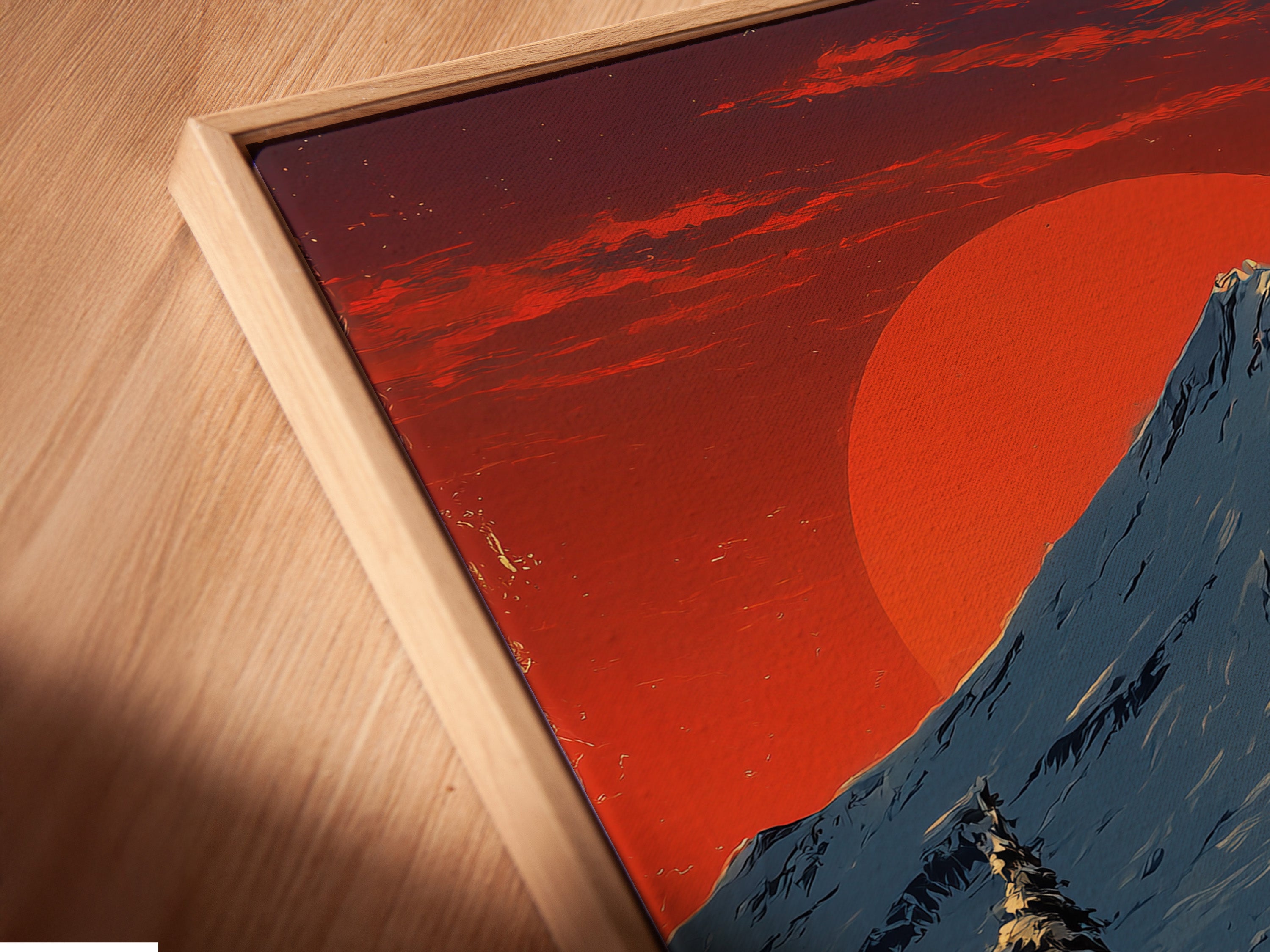 Angled close up of a canvas print in a floating frame. Winter mountain landscape artwork with a snowy cabin. Perfect rustic home decor. The primary color is red and secondary color is white.