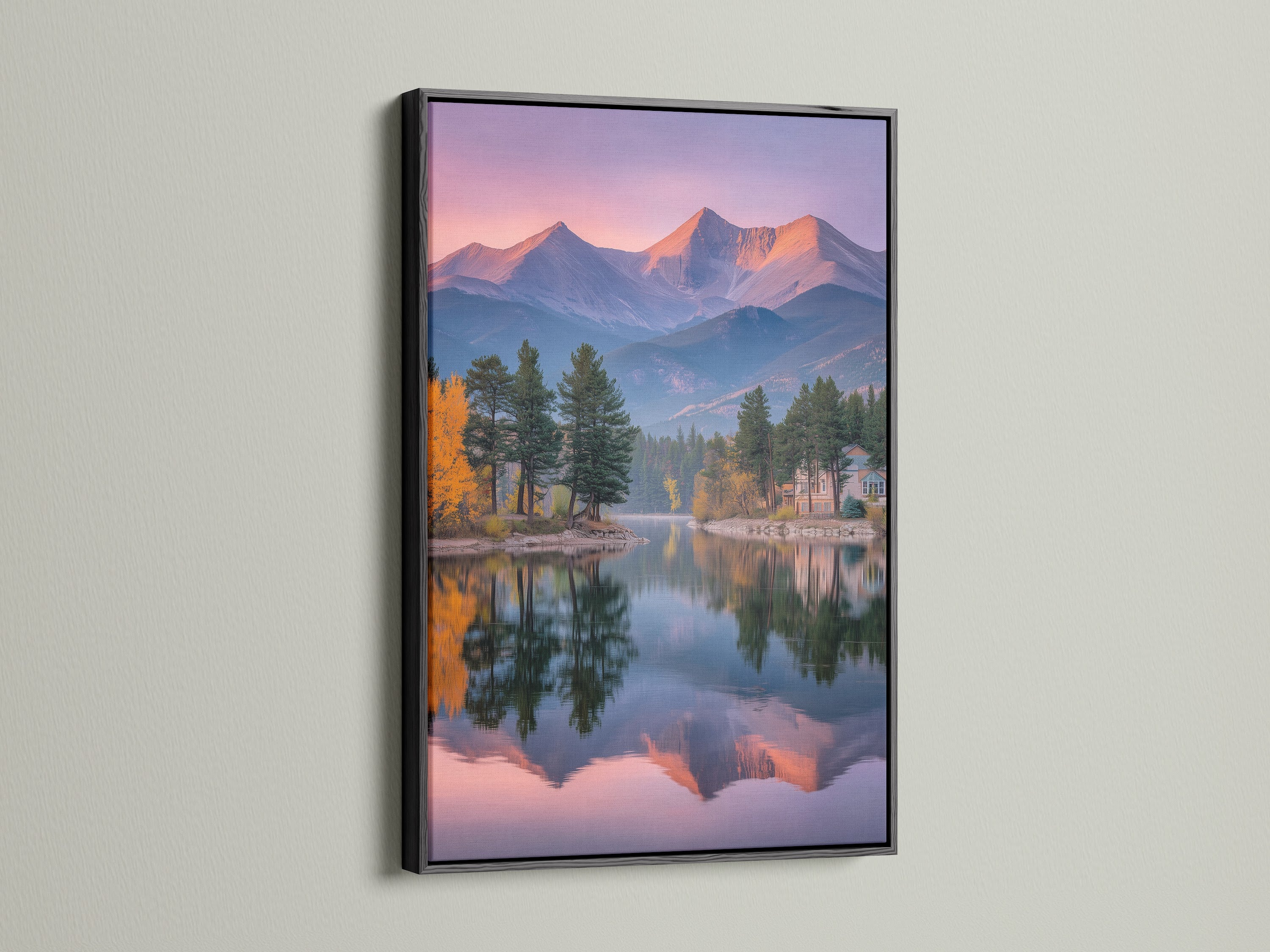 A black frame surrounds a mountain lake print. The art features Colorado peaks wall art. The pastel sky is reflected. This nature photography is great for offices. The scenic landscape is serene. The alpine art is tranquil. It is ideal for modern minimalist aesthetics.