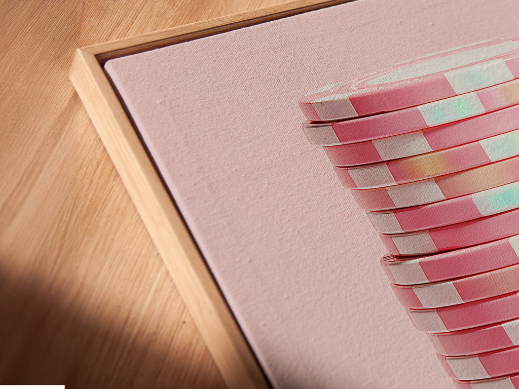 Angled close-up of a canvas print in a floating frame. The abstract geometric artwork showcases pink pastel hues. This modern minimalist art is perfect for contemporary spaces. Elevate your office wall decor with this unique piece.