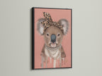 Black Frame highlights the Koala Wall Art. This trendy animal canvas print suits nurseries and kids' rooms. The Koala is adorned with a leopard print headband and pearl necklace. A stylish piece of modern animal art.
