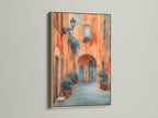 The Italian Alley artwork is displayed with an Oak Frame. The primary color of the artwork is orange and the secondary color is blue. This tuscan decor is perfect wall art for living rooms bedrooms offices studios lobbies clinics cafés and boardrooms