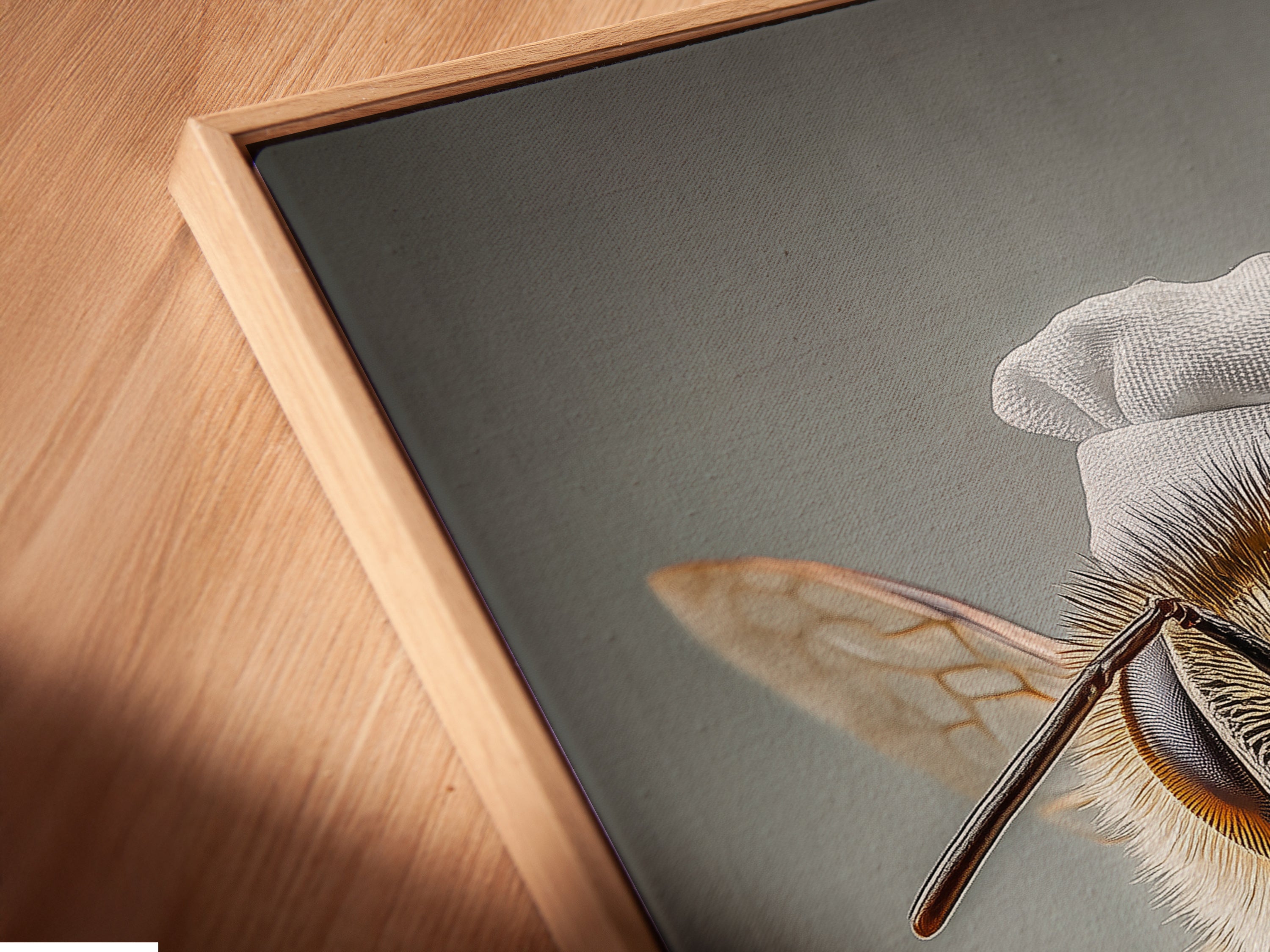Angled close up shows a canvas print of Chef Bee in a floating frame. The frame enhances the artwork's depth. It's quirky kitchen wall art. It's whimsical insect art for restaurants. See the unique floating frame detail.