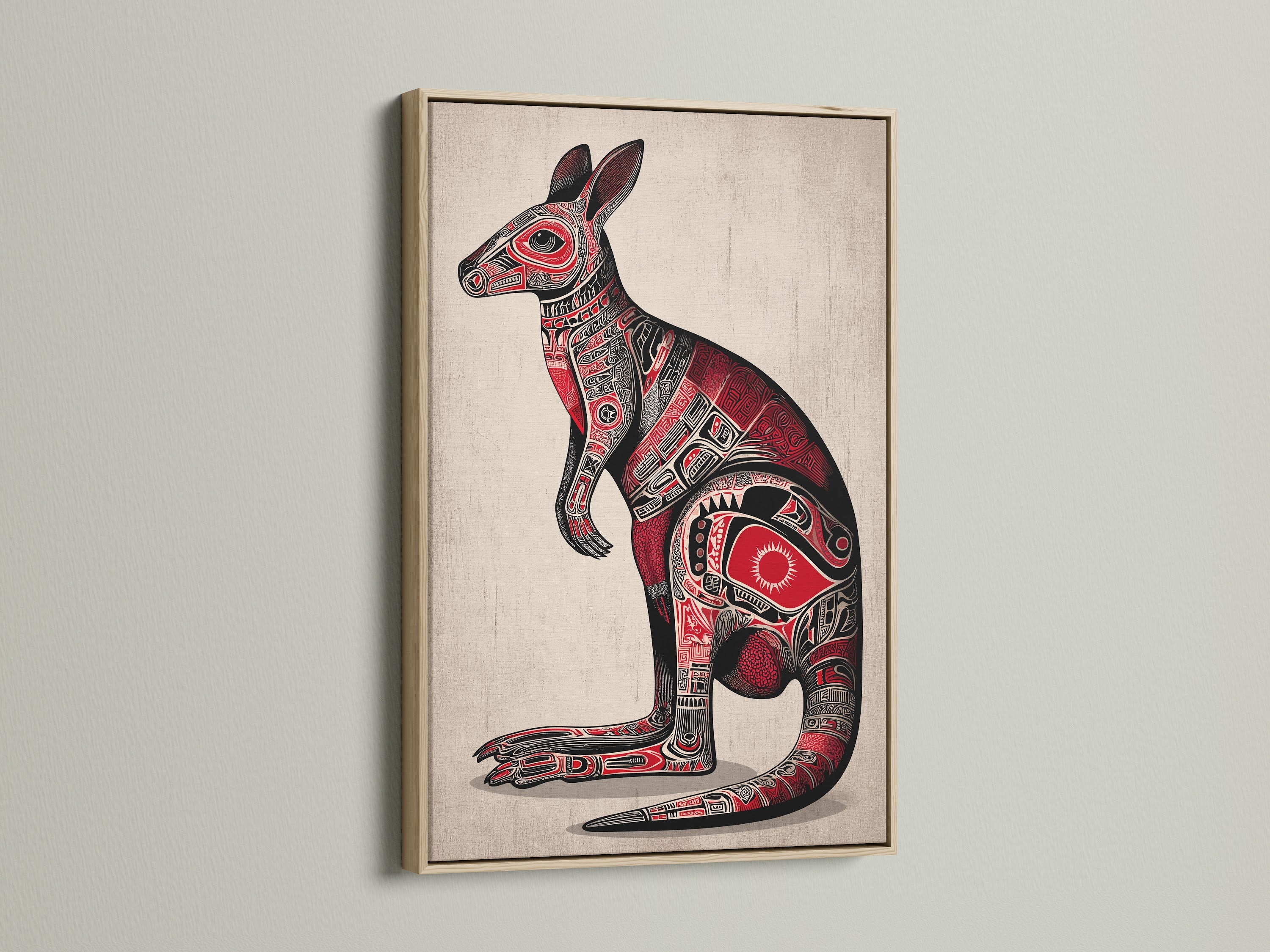 Aboriginal Kangaroo art print in an oak frame. The framed artwork hangs against a neutral wall. The art features a kangaroo with detailed indigenous patterns. The color palette includes red and black. This piece adds cultural richness to any space.