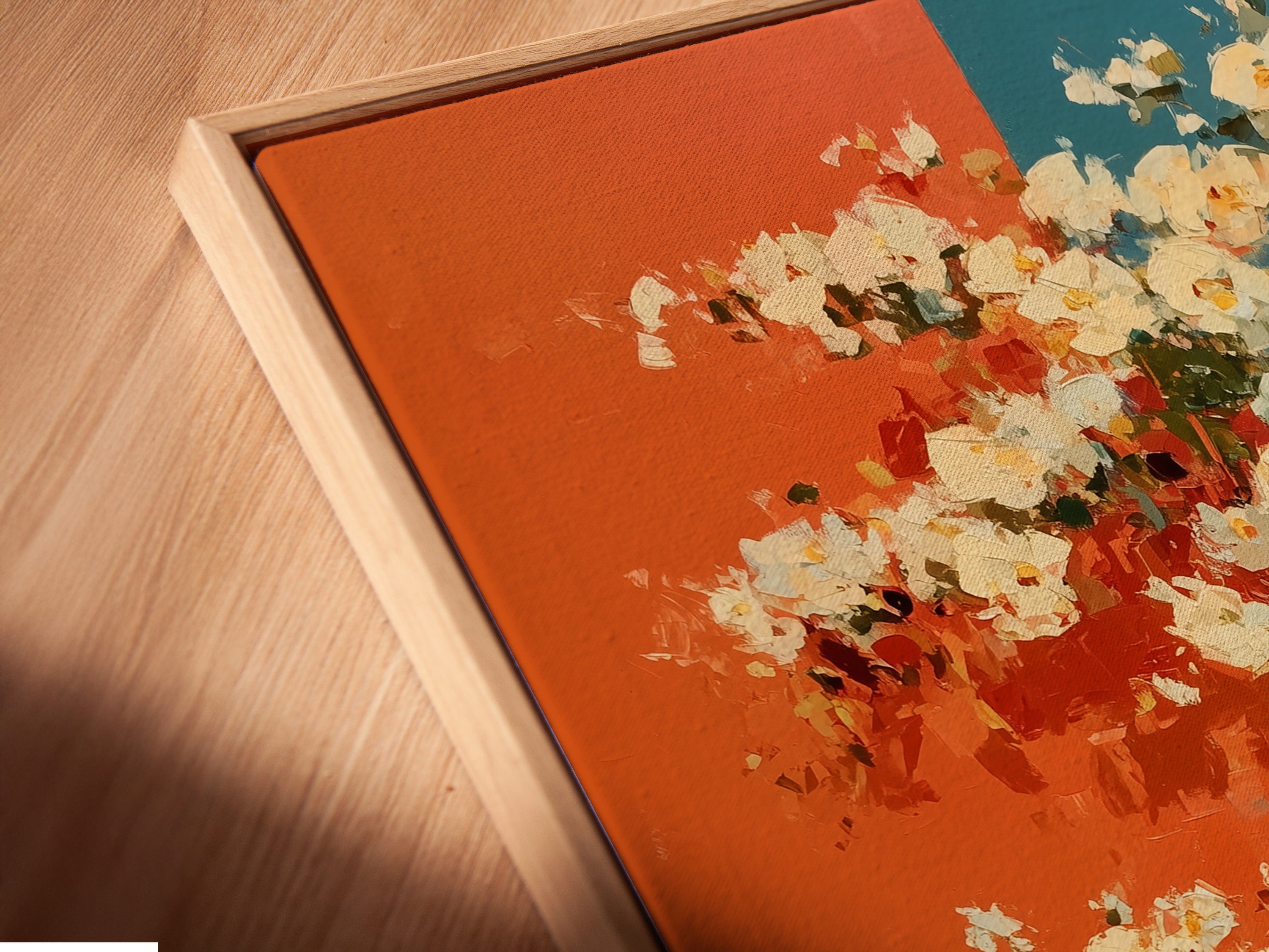 A close-up angled view of a canvas print in a floating frame. The vintage bicycle artwork features floral accents in coral and teal. This retro poster adds a touch of mid-century style to any kitchen or living room. The floating frame enhances the artwork’s modern appeal.